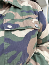 Load image into Gallery viewer, Close up view of the snap-closure pocket of a size 2X Forever 21 green camo denim jacket with snap closure buttons on a size 18/20 model.
