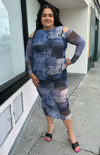 Load image into Gallery viewer, Full-body front view of size 16 Pretty Little Thing denim patchwork pattern mesh bodycon maxi dress with cold shoulders and sheer sleeves styled with black heels on a size 18/20 model.
