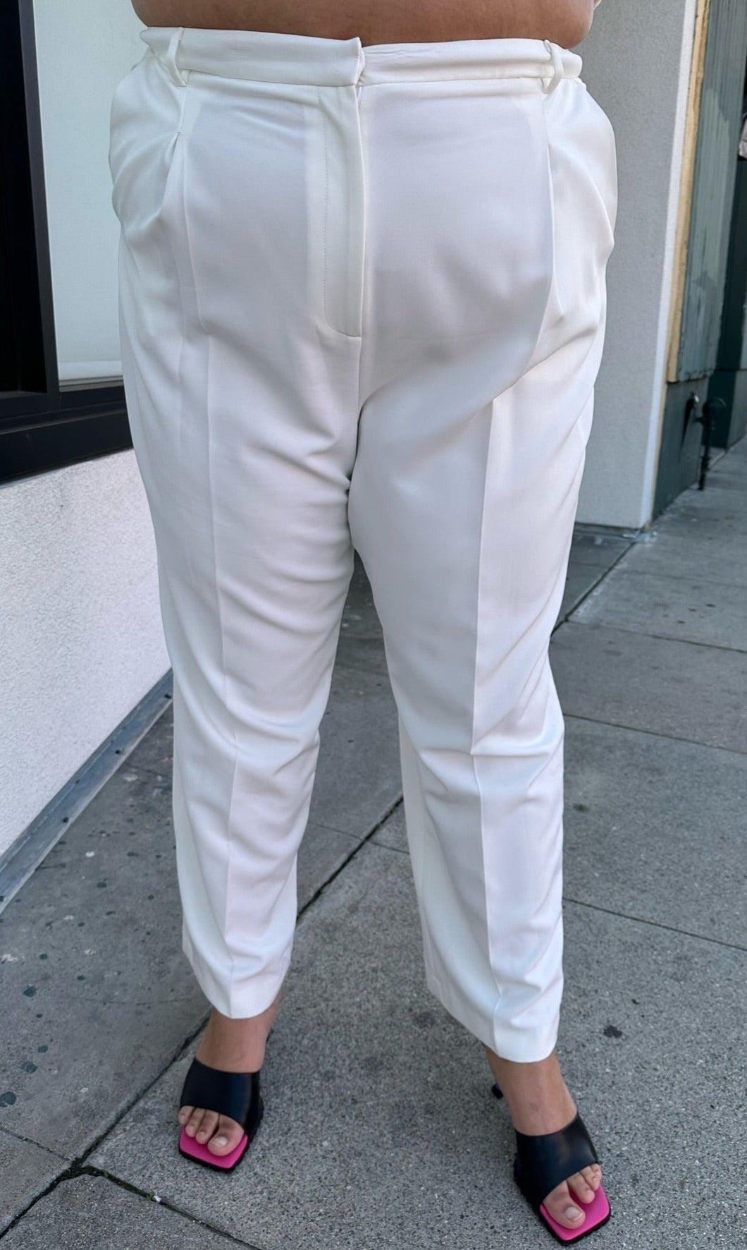 Front view of a pair of size 22 (fits like 18/20) Sally Lapointe for 11 Honoré white pleated tapered trousers on a size 18/20 model.