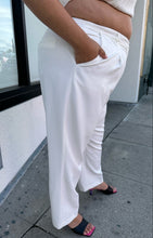 Load image into Gallery viewer, Side view of a pair of size 22 (fits like 18/20) Sally Lapointe for 11 Honoré white pleated tapered trousers on a size 18/20 model.
