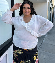 Load image into Gallery viewer, Front view of a size 4X SHEIN white sheer-leaning blouse with ruffled eyelet collar, all-over swiss dots, and smocked cuffs styled with a black wrap skirt on a size 18/20 model.
