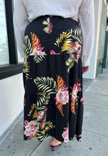 Load image into Gallery viewer, Back view of a size 4X SHEIN black tiered maxi skirt with pink, yellow, and green tropical floral pattern maxi skirt styled with a white blouse and black heels on a size 18/20 model.
