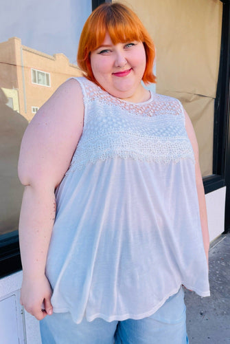 Front view of a size 3X Tru Self lightweight white tank with crochet lace details at the top styled with light wash jeans on a size 22/24 model.