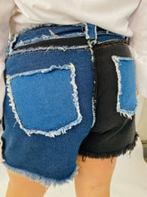 Load image into Gallery viewer, Back view of size 4X SHEIN light and dark wash patchwork denim shorts with unfinished hems and distressing details on a size 18 model.
