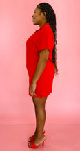 Load image into Gallery viewer, Full-body side view of a size L Everlane bright red 100% orangic cotton shortsleeve mini dress with collar detail styled with red heels on a size 14 model.
