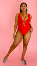 Load image into Gallery viewer, Full-body front view of a size XL Cupshe vibrant red strappy one piece swimsuit with a tortoiseshell ring detail styled with animal print flats on a size 14 model.
