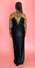 Load image into Gallery viewer, Full-body back view of a size 14 Melissa Mercedes black satin-y gown with gold, yellow, and silver sequin and beaded details on the neck and arms on a size 14 model.
