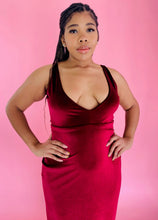Load image into Gallery viewer, Front view of a size 12/14 Melissa Mercedes deep red velvet floor-length gown with deep v-neck  and tie details at the back on a size 14 model.

