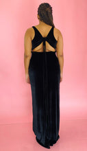 Load image into Gallery viewer, Full-body back view of a size 12/14 Melissa Mercedes black velvet floor-length gown with deep v-neck and tie details at the back on a size 14 model.
