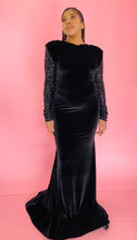 Load image into Gallery viewer, Additional full-body front view of a size 12/14 Melissa Mercedes black velvet floor-length gown with a high neckline, shoulder pad detail, black mesh and sequin sleeves and back, and a train on a size 14 model.
