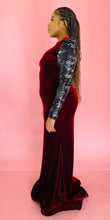 Load image into Gallery viewer, Full-body side view of a size 12/14 deep red velvet high-neck floor-length gown with black and silver sequin sleeves and back, shoulder pad details, and a train on a size 14 model.
