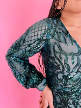 Load image into Gallery viewer, Detail shot of the intricate pattern and bead- and sequinwork on the sleeves of this size 12/14 Melissa Mercedes emerald green intricate mesh, beading, and sequined floor-length gown on a size 14 model.
