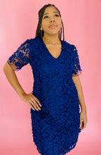 Load image into Gallery viewer, Front view of a size 14 Adrianna Papell navy blue midi dress with floral appliques and sheer mesh sleeves on a size 14 model.
