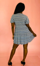 Load image into Gallery viewer, Full-body back view of a size L Andrea brand vintage sky blue, white, and black geometric print mini dress with black buttons up the front styled with black pumps on a size 10/12 model.
