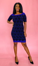 Load image into Gallery viewer, Full-body front view of a size 14/16 Milly for 11 Honoré purple and black square neck mini sheath dress with black floral mesh jacquard pattern styled with black pumps on a size 10/12 model.
