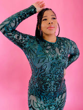 Load image into Gallery viewer, Closer view of the bodice and sleeves of a size 12/14 Melissa Mercedes emerald green body-hugging floor-length gown with intricate mesh, bead, and sequin work all throughout and a slit at the back on a size 14 model.
