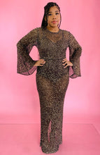 Load image into Gallery viewer, Additional full-body front view of a size 12/14 Melissa Mercedes sheer brown floor-length gown with gold sequin all-over pattern, wide bell sleeves, and back slit on a size 14 model.

