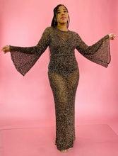 Load image into Gallery viewer, Full-body front view showing off the bell sleeves of a size 12/14 Melissa Mercedes sheer brown floor-length gown with gold sequin all-over pattern, wide bell sleeves, and back slit on a size 14 model.
