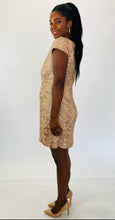 Load image into Gallery viewer, Full-body side view of this size 14 Jessica Howard gold sequin mini dress with high neck and cap sleeves styled with tan patent leather heels on a size 12 model.
