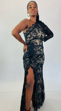 Load image into Gallery viewer, Additional full-body front view of this size 16 Monique Lhuillier for 11Honoré one-shoulder cream gown with sheer black lace overlay and high side slit styled with maroon strappy heels on a size 12 model.
