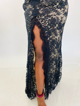 Load image into Gallery viewer, Close up detail shot of the high slit on the side of this size 16 Monique Lhuillier for 11Honoré one-shoulder cream gown with sheer black lace overlay and high side slit styled with maroon strappy heels on a size 12 model.
