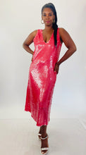 Load image into Gallery viewer, Full-body front view of a size 14 Dima Ayaad grapefruit pink colored v-neck gown with big sequins all throughout styled with shiny silver block heels on a size 12 model. The photo is taken inside under studio lighting.
