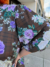 Load image into Gallery viewer, Close up view of the puff sleeve of a size 26 ASOS dark olive green, vibrant green, and lavender mixed print floral and plaid tiered maxi dress with puff sleeves on a size 22/24 model. The photo is taken outside in natural lighting.
