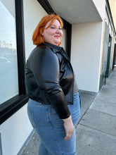 Load image into Gallery viewer, Side view of a size 12/14 (fits like 16/18) black pleather lightweight collared jacket styled over a plaid tank and medium wash denim on a size 22/24 model.
