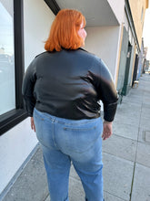 Load image into Gallery viewer, Back view of a size 12/14 (fits like 16/18) black pleather lightweight collared jacket styled over a plaid tank and medium wash denim on a size 22/24 model.
