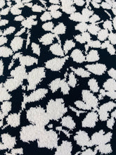 Load image into Gallery viewer, Close up detail shot of the super textured fabric of this size M Michael Kors black and white textured floral sheath midi dress with cap sleeves
