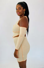 Load image into Gallery viewer, Side view of a size 1X Fashion Nova light tan and orange exposed seam 2-piece with zip-up extreme cold shoulder halter top and bodycon mini skirt on a size 12 model.
