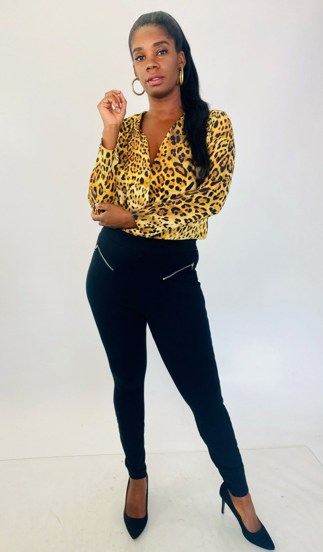 Full-body front view of a pair of size L A New Day black tapered slacks with zipper front pockets styled with a silky leopard print bodysuit and black pumps on a size 12 model.
