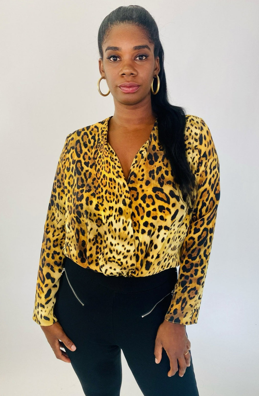 Front view of a size XL Cushnie 100% silk leopard print long sleeve bodysuit styled with black tapered slacks on a size 12 model.