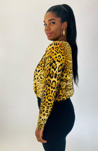 Load image into Gallery viewer, Side view of a size XL Cushnie 100% silk leopard print long sleeve bodysuit styled with black tapered slacks on a size 12 model.
