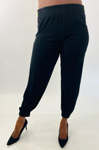 Load image into Gallery viewer, Front view of a pair of size 14 Haney for 11Honoré black slit calf joggers styled with black pumps on a size 12 model.
