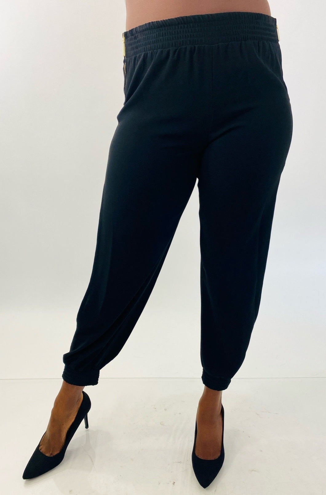 Front view of a pair of size 14 Haney for 11Honoré black slit calf joggers styled with black pumps on a size 12 model.
