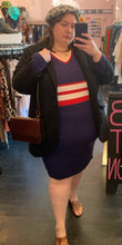 Load image into Gallery viewer, Full-body front view of a size 22/24 Eloquii x Katie Sturino navy blue ribbed knit sweater dress with red and white varisty stripes and a red and white v-neck stripe styled with a black coat, a gray leopard beret, and brown reptile handbag and shoes on a size 24 model.
