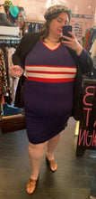 Load image into Gallery viewer, Full-body front view of a size 22/24 Eloquii x Katie Sturino navy blue ribbed knit sweater dress with red and white varisty stripes and a red and white v-neck stripe styled with the black coat pulled back to show the dress, a gray leopard beret, and brown reptile handbag and shoes on a size 24 model.
