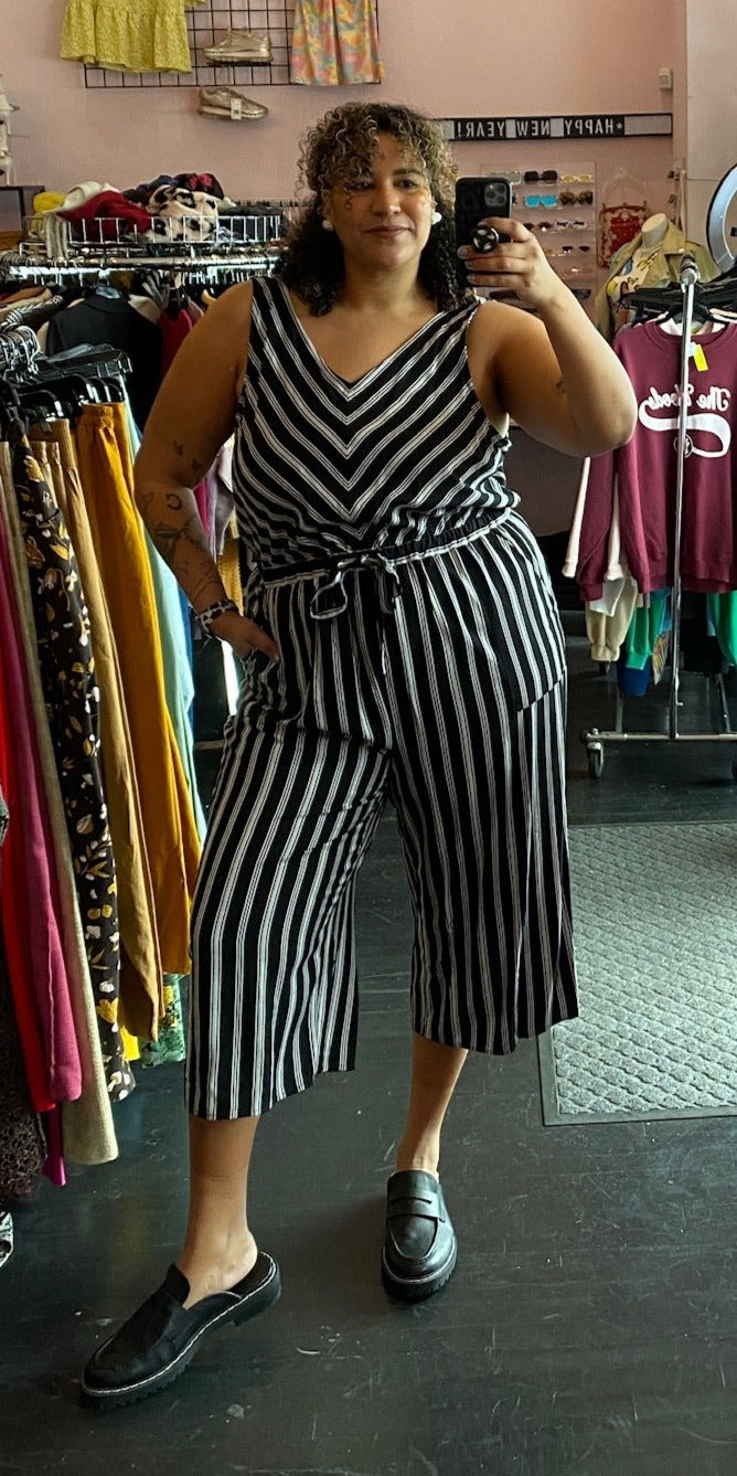Full-body front view of a size 2X CJ Banks black and white striped crop jumpsuit with drawstring waist styled with black loafers on a size 16/18 model.