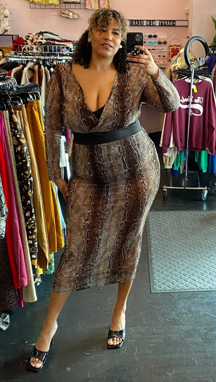 Full-body front view of a size 3X K Glam brown, tan, white, and black neutral tone snake print mesh maxi dress with black bodysuit lining and black belt detail styled with black heels on a size 16/18 model.