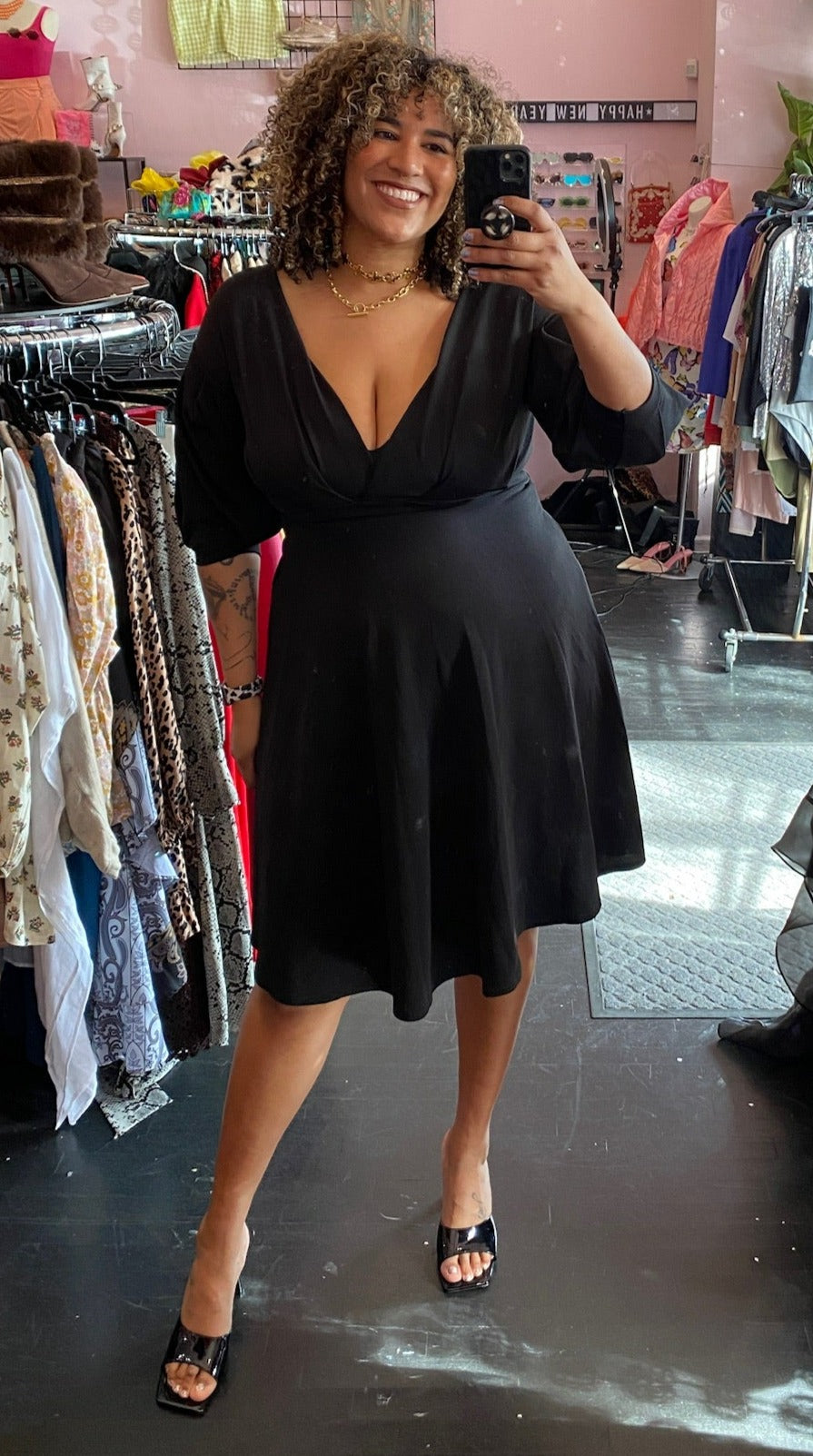 Full-body front view of a size 16 Boohoo black v-neck three-quarter sleeve a-line midi dress styled with black kitten heels on a size 16/18 model.
