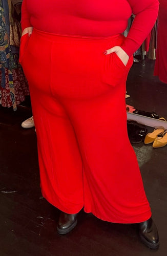 Close front view of a size XXXL Zelie for She bright red wide leg stretchy palazzo pant styled with a red turtleneck on a size 22/24 model.