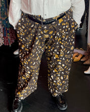 Load image into Gallery viewer, Front view of a pair of size 6XL Big Bud Press dark brown, mustard yellow, and white mixed mushroom and floral pattern work pants styled with a cream button-up shirt and black loafers on a size 24/26 model.
