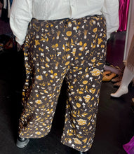 Load image into Gallery viewer, Back view of a pair of size 6XL Big Bud Press dark brown, mustard yellow, and white mixed mushroom and floral pattern work pants styled with a cream button-up shirt and black loafers on a size 24/26 model.
