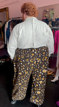 Load image into Gallery viewer, Full-body back view of a pair of size 6XL Big Bud Press dark brown, mustard yellow, and white mixed mushroom and floral pattern work pants styled with a cream button-up shirt and black loafers on a size 24/26 model.
