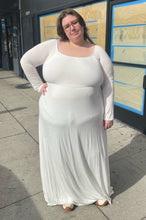Load image into Gallery viewer, Full-body front view of a size 3X Pink Blush brand off-white floor length maxi dress with scoop neck on a size 24 model. The photo is taken outside in natural lighting.
