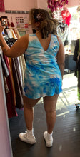 Load image into Gallery viewer, Full-body back view of a size 18 Collusion brand bright blue, light blue, and white acid wash tie dye mini dress styled with white sneakers on a size 16/18 model.
