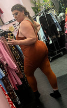 Load image into Gallery viewer, Full-body back view of a size 3X Nike copper colored one-piece active jumpsuit with built in bar and shorts detail on a size 14/16 model.
