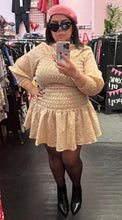 Load image into Gallery viewer, Additional full-body front view of a size L H&amp;M light cream smocked torso mini dress with puff sleeves and a high neckline styled with black tights and black hoots on a size 14/16 model.
