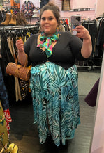 Load image into Gallery viewer, Additional full-body front view of a size 22 Novella brand blue and teal zebra print wrap maxi skirt styled with a black button up cardigan on a size 22/24 model.
